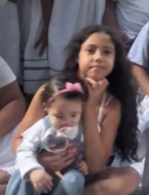 Menina do templo vestida de branco com um bebê no colo